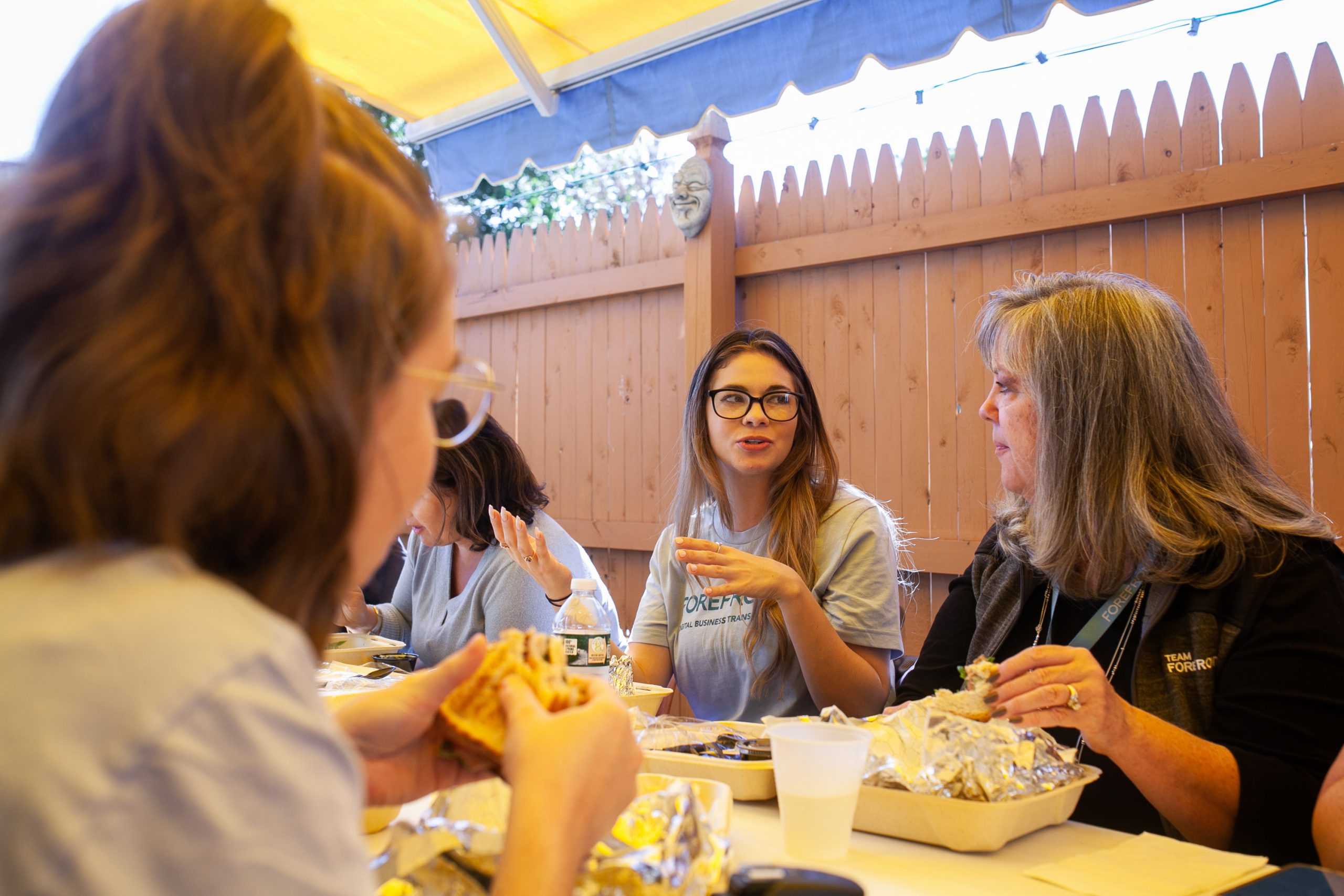 A group of women enjoying a meal together at an outdoor table.